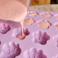 Pouring frozen yoghurt mixture into a paw-shaped silicone mould